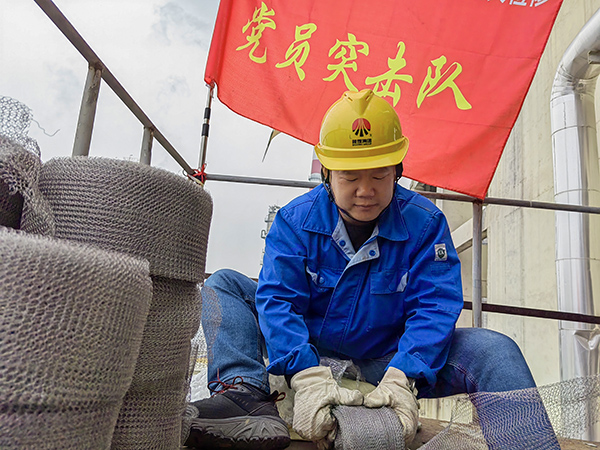 5月10日中午，在動力車間三期工藝除氧器平臺上，黨員突擊隊隊長李鑫正在纏繞新填料.jpg