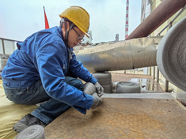 5月10日中午，在動力車間三期工藝除氧器平臺上，黨員突擊隊隊員劉瑞斌正在纏繞新填料.jpg