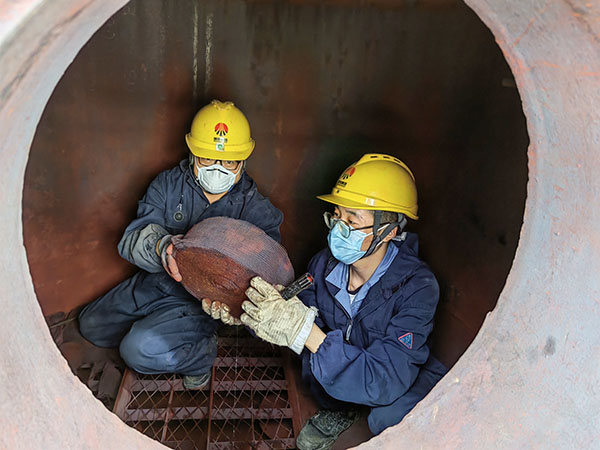 5月11日，動力車間三期工藝除氧器內部，黨員突擊隊隊員劉瑞斌和李震正在清理舊填料.jpg