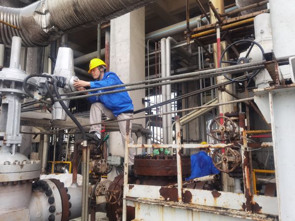 氣化爐上，柳曦、徐騰飛冒雨調(diào)試氣化爐電動(dòng)閥.jpg